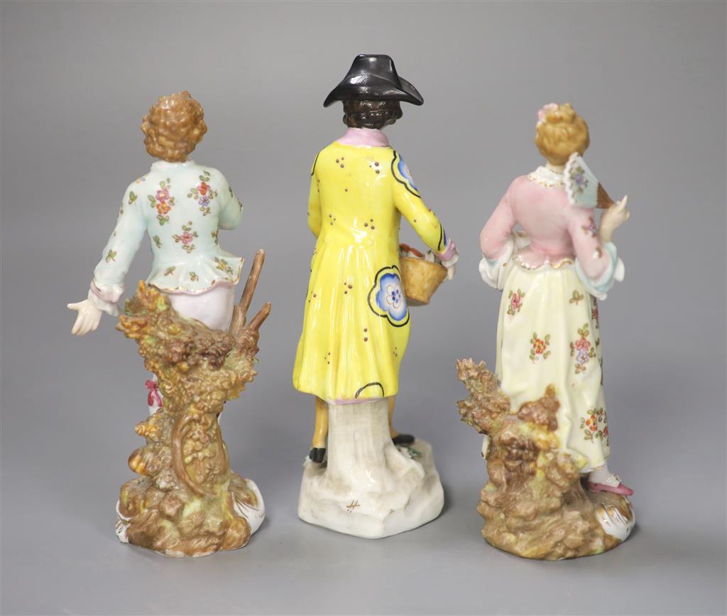 A pair of Continental figurines and a fruit seller, tallest 17cm